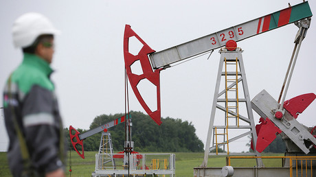 A worker looks at a pump jack in Ufa, Bashkortostan, Russia © Sergey Karpukhin