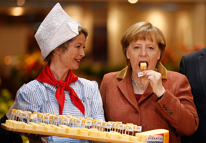 German Chancellor Angela Merkel (R) samples cheese at the pavilion of the Netherlands at the Green Week agricultural fair in Berlin, January 18, 2013 (Reuters / Thomas Peter)
