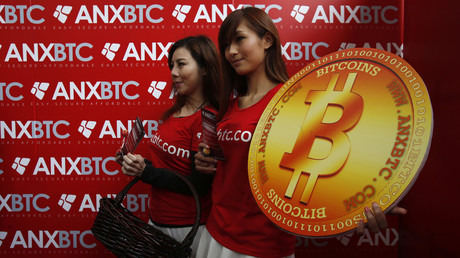 Attendants pose with a bitcoin sign during the opening of Hong Kong's first bitcoin retail store February 28, 2014 © Bobby Yip