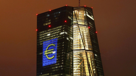 The headquarters of the European Central Bank (ECB) are illuminated with a giant euro sign at the start of the 