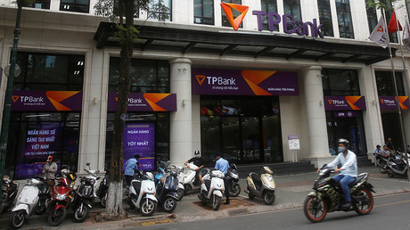 A man rides a motorcycle past the Vietnamese commercial Tien Phong bank in Hanoi May 13, 2016 © Kham