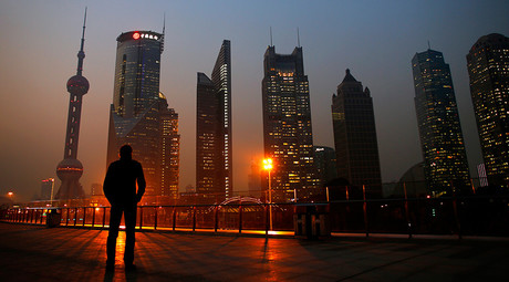 A man looks at the Pudong financial district of Shanghai © Carlos Barria 