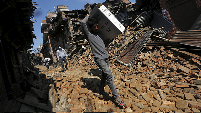 A man carries a television which he recovered from the rubbles of his house after an earthquake in Bhaktapur, Nepal April 27, 2015 (Reuters / Adnan Abidi)