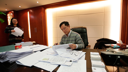 Guan Jianzhong, chairman of Beijing-based Dagong Global Credit Rating Co, works at his office in Beijing (Reuters / Jason Lee)