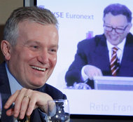Duncan Niederauer, left, chief of NYSE Euronext, with Reto Francioni of Deutsche Börse, on video, at a news conference in February.
