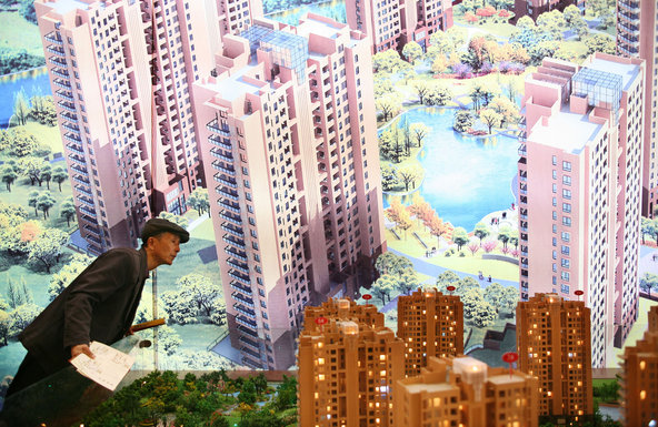 Visitors looking at housing models during the 24th Shanghai Real Estate Exhibition and Trade Fair.