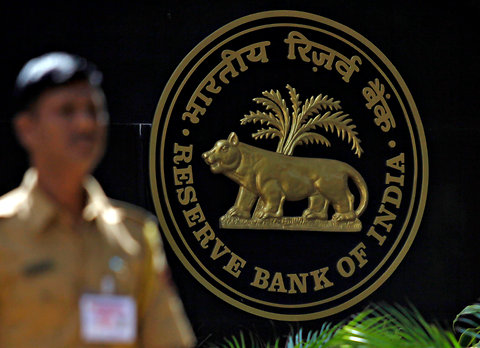 A policeman walks past the logo of the Reserve Bank of India outside its head office in Mumbai, Maharashtra in this Nov. 2, 2010 file photo.