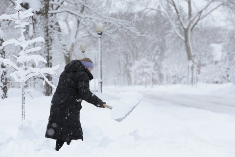 A woman shovels snow after a spring storm in Fargo, N.D.