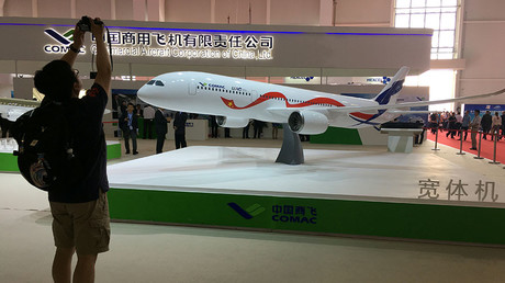 A man takes picture of the model of a widebody jet, which is planned to be developed by Commercial Aircraft Corporation of China and Russia's United Aircraft Corporation at an air show, the China International Aviation and Aerospace Exhibition, in Zhuhai, Guangdong Province, China, November 2, 2016.