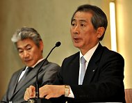 Kenichi Watanabe, right, announces his resignation on Thursday as his successor, Koji Nagai, looks on.