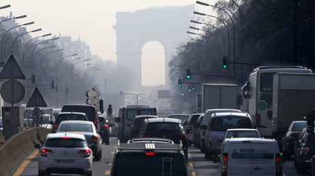 Rush hour traffic fills an avenue leading up to the Arc de Triomphe which is seen through a small-particle haze at Neuilly-sur-Seine, Western Paris © Charles Platiau