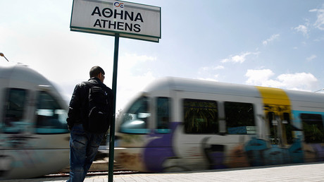  A man stands as a train passes in front of him at a central train station in Athens © John Kolesidis