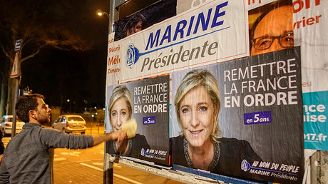 Member of the National Front youths puts up presidential campaign posters of Marine Le Pen © Robert Pratta