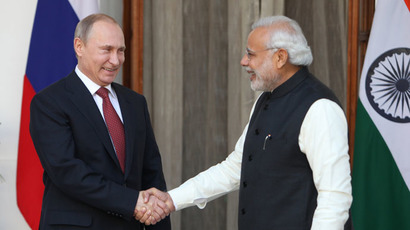 Russian President Vladimir Putin (L) shakes hands with Indian Prime Minister Narendra Modi at Hyderabad House in New Delhi on December 11, 2014. (AFP Photo/Findlay Kember)