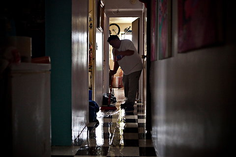 A man in New York City sweeps water out of his apartment after Hurricane Sandy.
