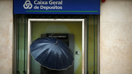 A man uses an ATM machine at a Caixa Geral Depositos branch in downtown Lisbon, Portugal. © Rafael Marchante