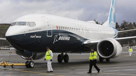 Ground crew members escort a Boeing 737 MAX as it returns from a flight test at Boeing Field in Seattle, Washington © Jason Redmond