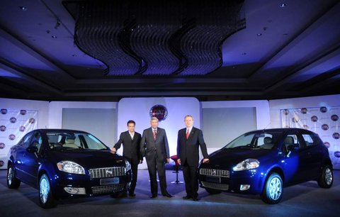 Executives pose in front of the newly launched Fiat Linea and Fiat Punto in Delhi on Tuesday.