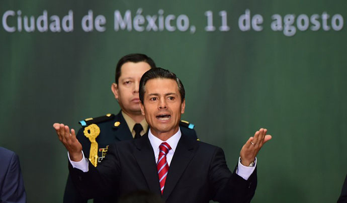 Mexican president Enrique Pena Nieto delivers a speech before signing the new law of energy, in Mexico City, on August 11, 2014. (AFP Photo / Ronaldo Schemidt)