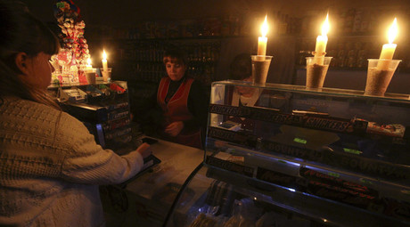 A customer visits a grocery lit with candles due to a power cut, in Simferopol, Crimea, November 22, 2015. © Pavel Rebrov