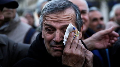 A Greek pensioner wipes his face with a fake euro banknote during a demonstration against government policies affecting pensioners in Athens © Alkis Konstantinidis