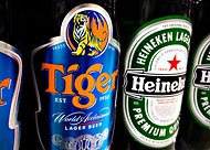 Bottles of Tiger and Heineken beers on the shelf of a grocery store in Singapore.