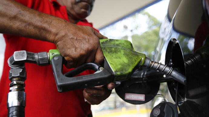 A man pumps gasoline at a service station in Caracas August 7, 2014. (Reuters/Jorge Silva)