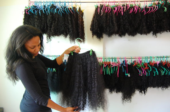 Janice Wilson, founder of Arjuni, shows a finished hair extension, ready for shipping from Phnom Penh, Cambodia.