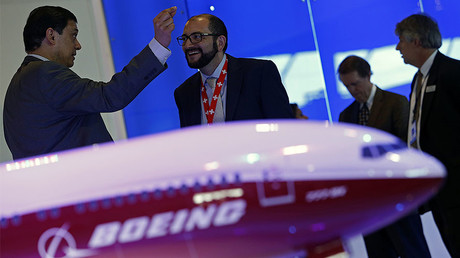 Visitors talk next to a Boeing 777X aircraft model at the Singapore Airshow © Edgar Su